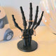 3D printed skeleton hand ring holder in white with rings on each finger