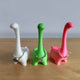 3D printed cute dinosaur ring holder in green with rings displayed on body