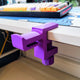 3D printed desk mount headphone hanger clamp in black holding gaming headphones under desk